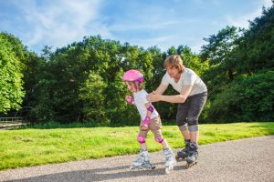 Complete beginner roller skating, her father helping her