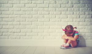 little child girl crying and sad about an empty brick wall